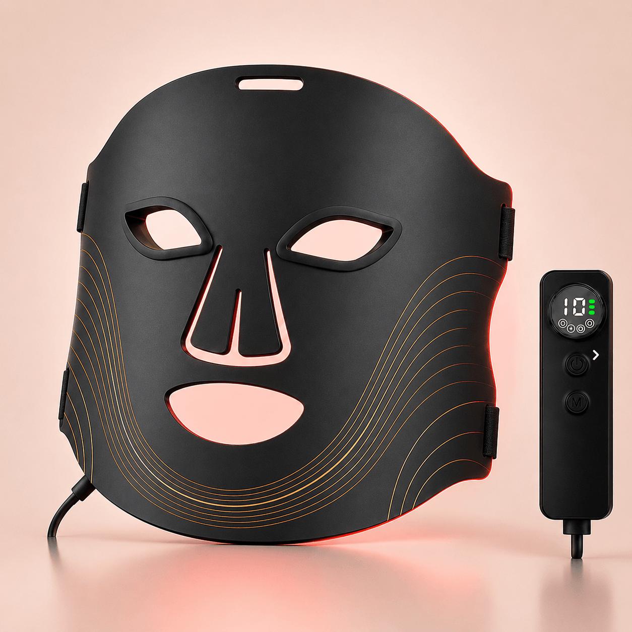 Red light facial mask therapy device with a black contoured mask and a separate handheld controller, shown on a soft peach background.
